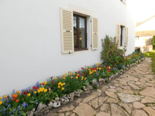 un lecho de flores frente a una casa con flores en Maisonnette avec jardin 