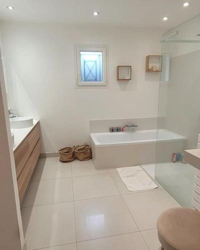 une salle de bain blanche avec une baignoire et un lavabo dans l'établissement Villa de standing proche Airbus et Meet, à Aussonne