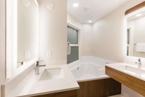 a white bathroom with two sinks and a tub at Holiday Inn Express Grande Prairie, an IHG Hotel in Grande Prairie