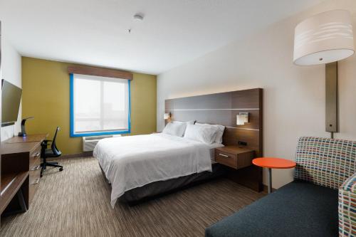 a hotel room with a bed and a desk and a chair at Holiday Inn Express Grande Prairie, an IHG Hotel in Grande Prairie