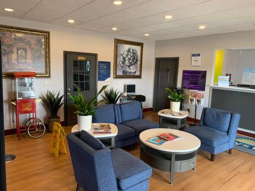 a waiting room with blue chairs and tables at Days Inn by Wyndham Louisville Airport Fair and Expo Center in Louisville