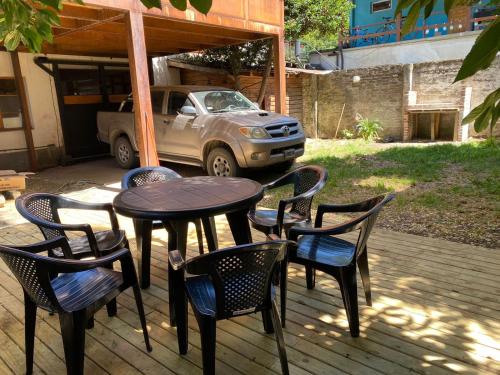 una mesa y sillas en un patio con un camión en Departamentocasa zona centro en San Martín de los Andes