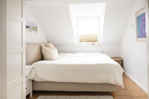 um quarto branco com uma cama e uma janela em Ko-Living - urbanes Apartment am Zoo em Giebichenstein