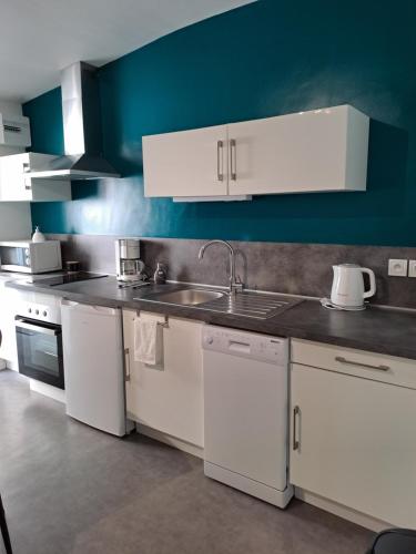 une cuisine avec des armoires blanches et un évier dans l'établissement Logement idéal curistes, à Rochefort