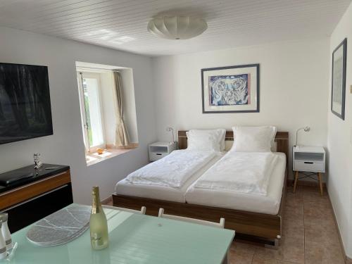 a white bedroom with a bed and a table at Chalet Casa Sharm in Saas-Fee