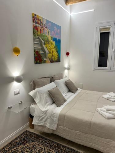 a white bedroom with a bed and a painting on the wall at Suite Battisti 7 in Lecce