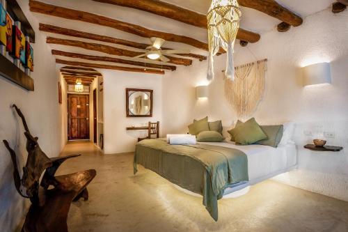 a bedroom with a bed and a ceiling fan at Beachfront Hotel La Palapa - Adults Only in Holbox Island