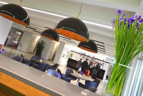 a dining room with blue chairs and tables and lights at Hotel HP Park Poznań Malta in Poznań