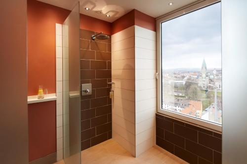 a bathroom with a shower with a large window at Best Western Plus Arosa Hotel in Paderborn