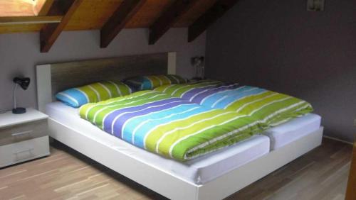 a bed with colorful blankets and pillows on it at Ferienwohnung Kuhn in Weilbach