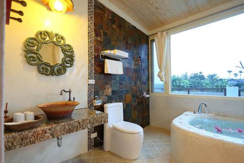 a bathroom with a tub and a toilet and a sink at Cloudenjoy B&B in Hualien City