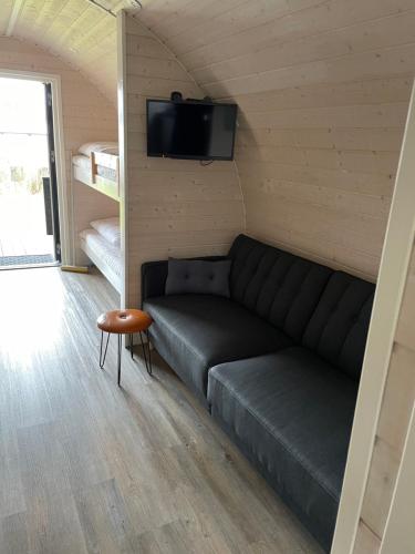 uma sala de estar com um sofá e uma televisão de ecrã plano em Vorbasse camping em Vorbasse