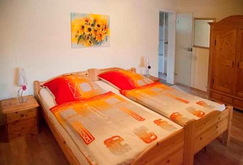 バート・ケーニヒにあるHaus Meckbachのベッドルーム1室(大型木製ベッド1台、オレンジ色の枕付)