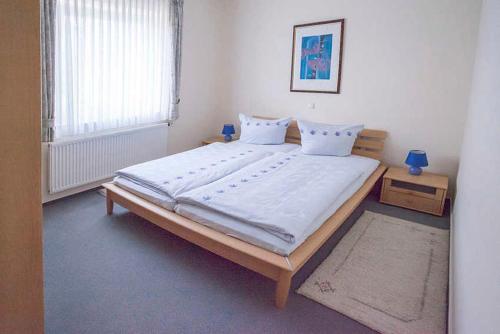 巴特科尼希的住宿－Haus Ulla，一间卧室配有一张带白色床单的大床