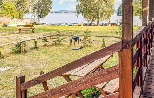 a wooden fence with a table in a field at 2 Bedroom Cozy Home In Biskupiec in Biskupiec