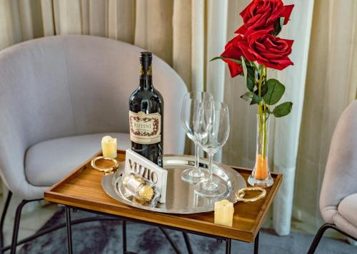 エンカルナシオンにあるMako´s Hotelのグラスとバラの上に置かれたワイン1本