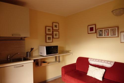 a living room with a red chair and a microwave at Casa Vacanze Le Muse Sillico in Pieve Fosciana