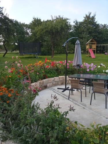 a patio with a table and chairs and flowers at Gajówka in Wünschelburg