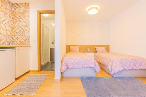 um quarto com 2 camas e uma cabina de duche ao nível do chão em Porto Island no Porto