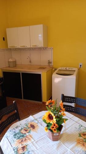 una cocina con una mesa con flores. en Ótimo apartamento, en Manaus