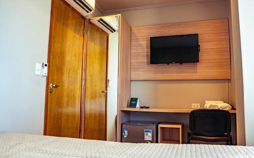 - une chambre avec un lit et une télévision à écran plat dans l'établissement Mako´s Hotel, à Encarnación