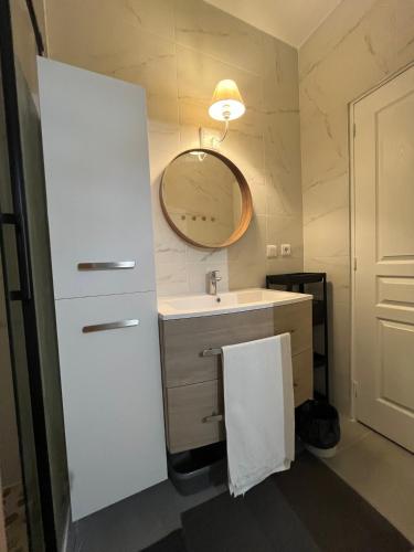 une salle de bain avec un lavabo blanc et un miroir dans l'établissement Dream Dwell Paris-Cozy historic appartement near Exelmans in 16th District Paris, à Paris