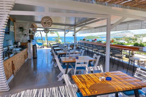 a restaurant with tables and chairs and the ocean at Hotel Ajden by Mira Mare in Ksamil