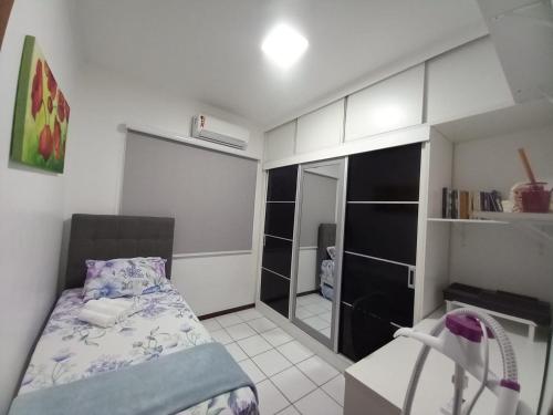 małą sypialnię z łóżkiem i lustrem w obiekcie Village - Condomínio Mansão da Lagoa w mieście Salvador