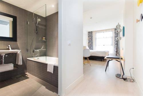 een badkamer met een bad, een wastafel en een douche bij Vincci Bit in Barcelona