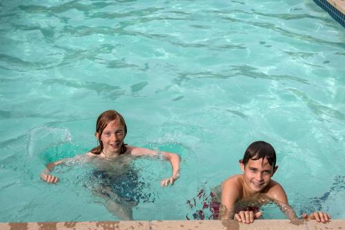 two people are swimming in a swimming pool at Bear Creek Lodge by Alpine Lodging Telluride in Telluride