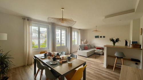 un salon avec une table et des chaises dans une pièce dans l'établissement « BLEU COMME MER » à deux pas des plages, à Concarneau