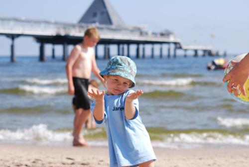 a young boy standing on the beach near the ocean at Hotel Wald und See in Heringsdorf