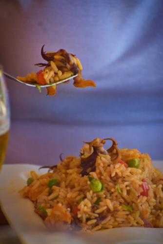 a plate of food with rice on a fork at Prim Hotel Vichayito in Vichayito