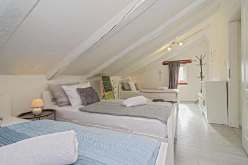 two beds in a room with a attic at Filip in Kraj Drage (Haus für 4-5 Personen) in Nedeščina
