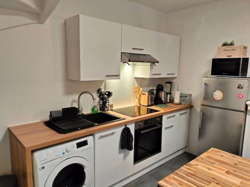 une cuisine avec un évier et un lave-vaisselle dans l'établissement Locanoor Dieppe - Maison de Pêcheur devenue Cosy, à Dieppe