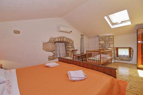 a bedroom with a large bed and a stone fireplace at Erika in Šumber (Haus für 4-6 Personen) in Nedeščina