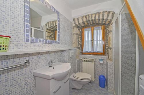 a bathroom with a sink and a toilet and a mirror at Erika in Šumber (Haus für 4-6 Personen) in Nedeščina