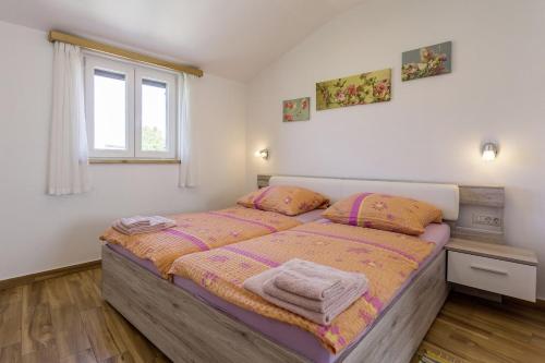 een slaapkamer met een bed met 2 kussens en een raam bij Villa Rina in Barat (Haus für 6-8 Personen) in Kanfanar