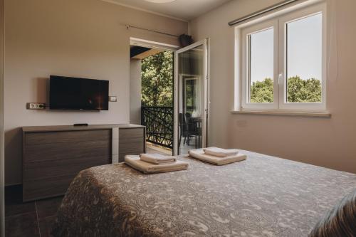a bedroom with a bed and a tv and windows at Luxury Villa Četiri Hrasta in Pićan
