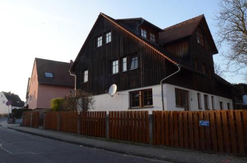 ein Haus mit einem Holzzaun davor in der Unterkunft Apartment Albert in Erbach