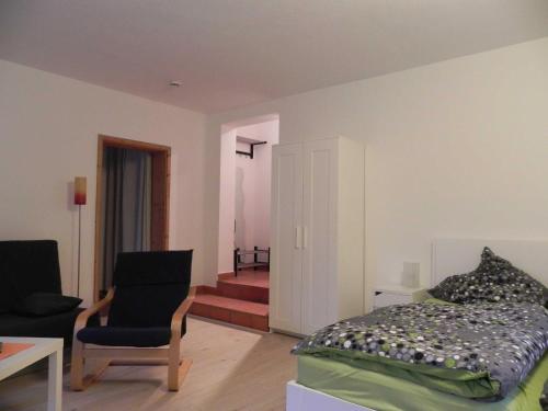 ein Schlafzimmer mit einem Bett, einem Stuhl und einem Tisch in der Unterkunft Apartment Albert in Erbach