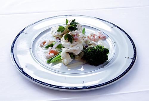 a plate of food with shrimp and broccoli on a table at Sogndalstrand Kulturhotell in Sogndalsstrand