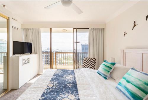 Schlafzimmer mit einem Bett, einem TV und einem Balkon in der Unterkunft Spacious & Magnificent Views Apartment in Gold Coast