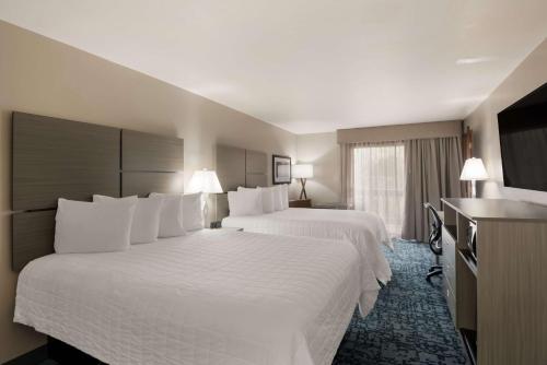 a hotel room with two beds and a television at Best Western New Oregon Motel in Eugene
