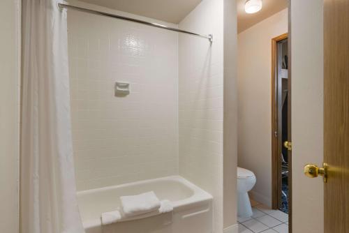 a white bathroom with a tub and a toilet at Best Western New Oregon Motel in Eugene