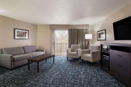 a hotel room with a couch and chairs and a television at Best Western New Oregon Motel in Eugene