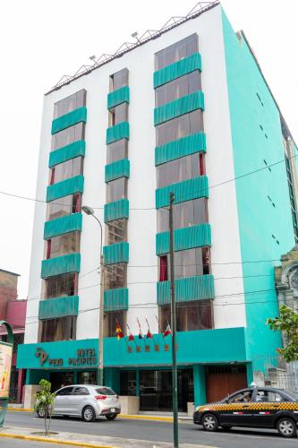 a building on a street with cars parked in front of it at Hotel Perú Pacífico in Lima