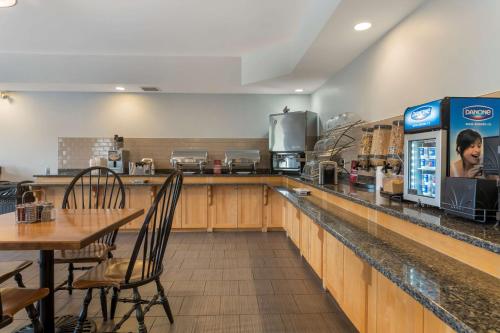 a restaurant with a bar with a table and chairs at Best Western Plus Liverpool Hotel & Conference Centre in Liverpool