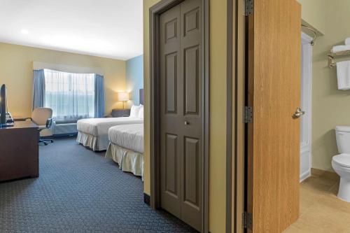 a room with two beds and a bathroom with a toilet at Best Western Plus Liverpool Hotel & Conference Centre in Liverpool