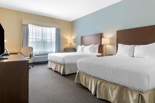 a hotel room with two beds and a television at Best Western Plus Liverpool Hotel & Conference Centre in Liverpool